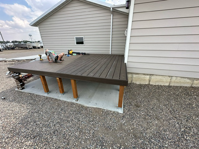 A wooden deck is being built in front of a house.