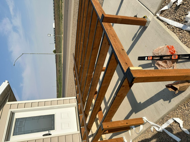 A wooden structure is being built next to a house
