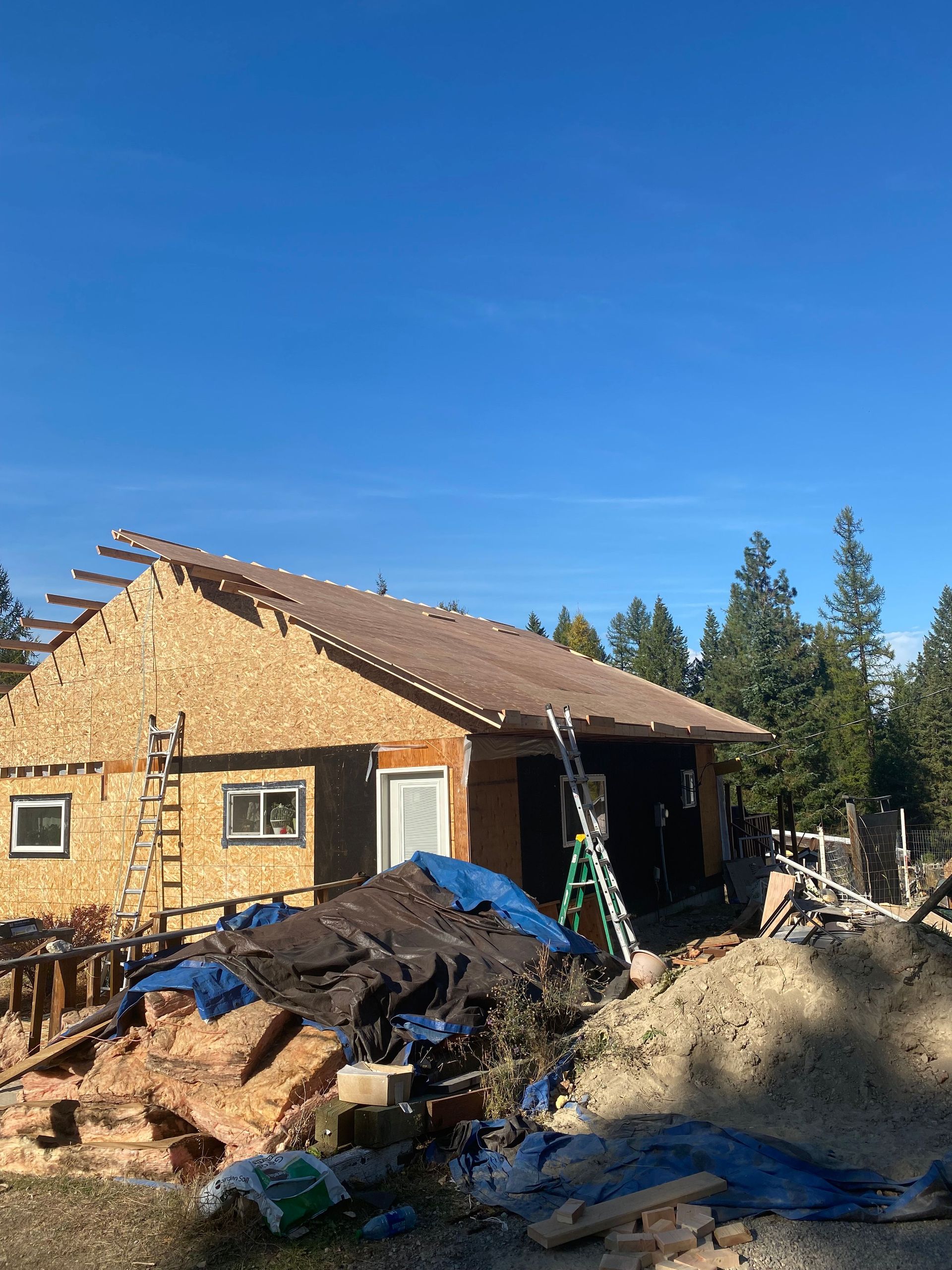 A house under construction with a ladder in front of it.