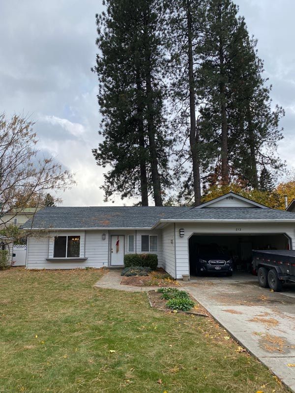 A white house with a black truck parked in front of it.