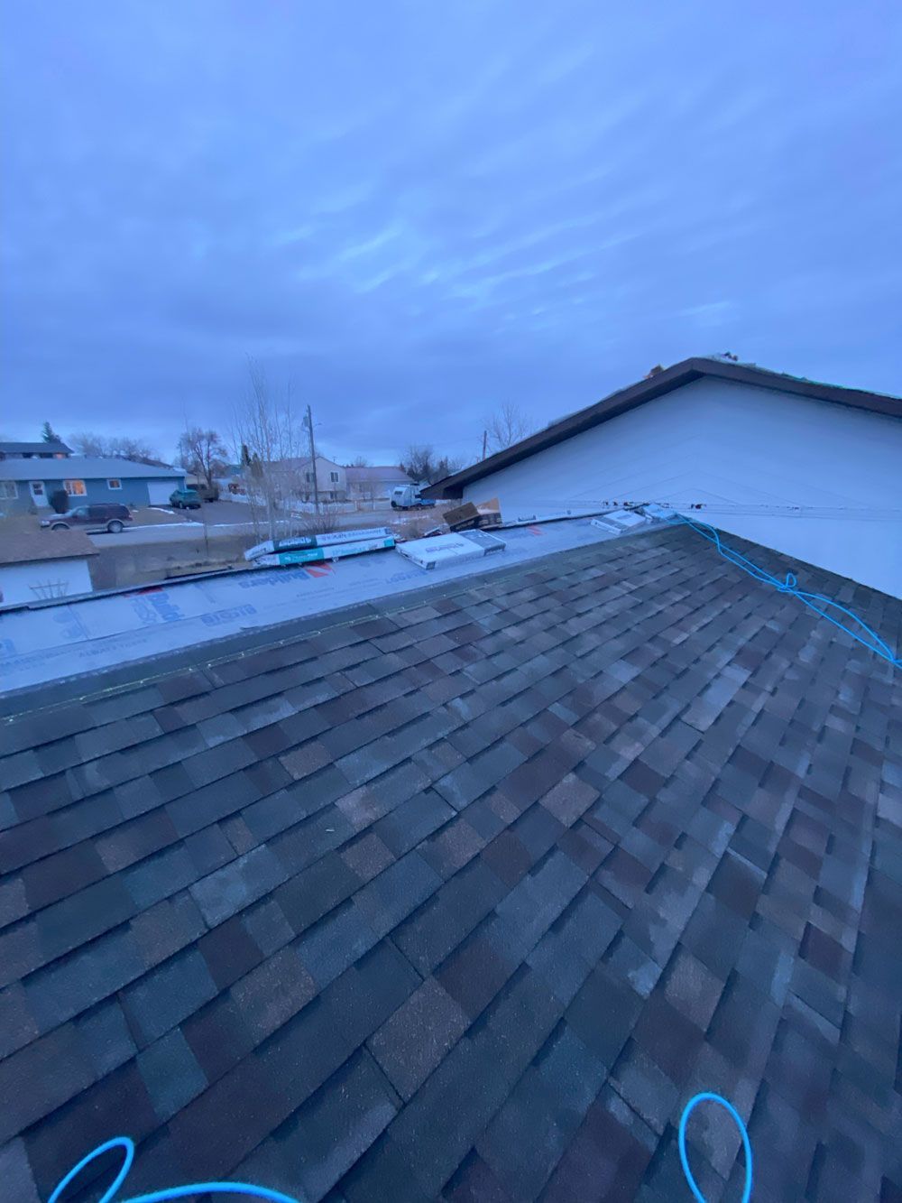 A roof of a house with a blue hose attached to it.