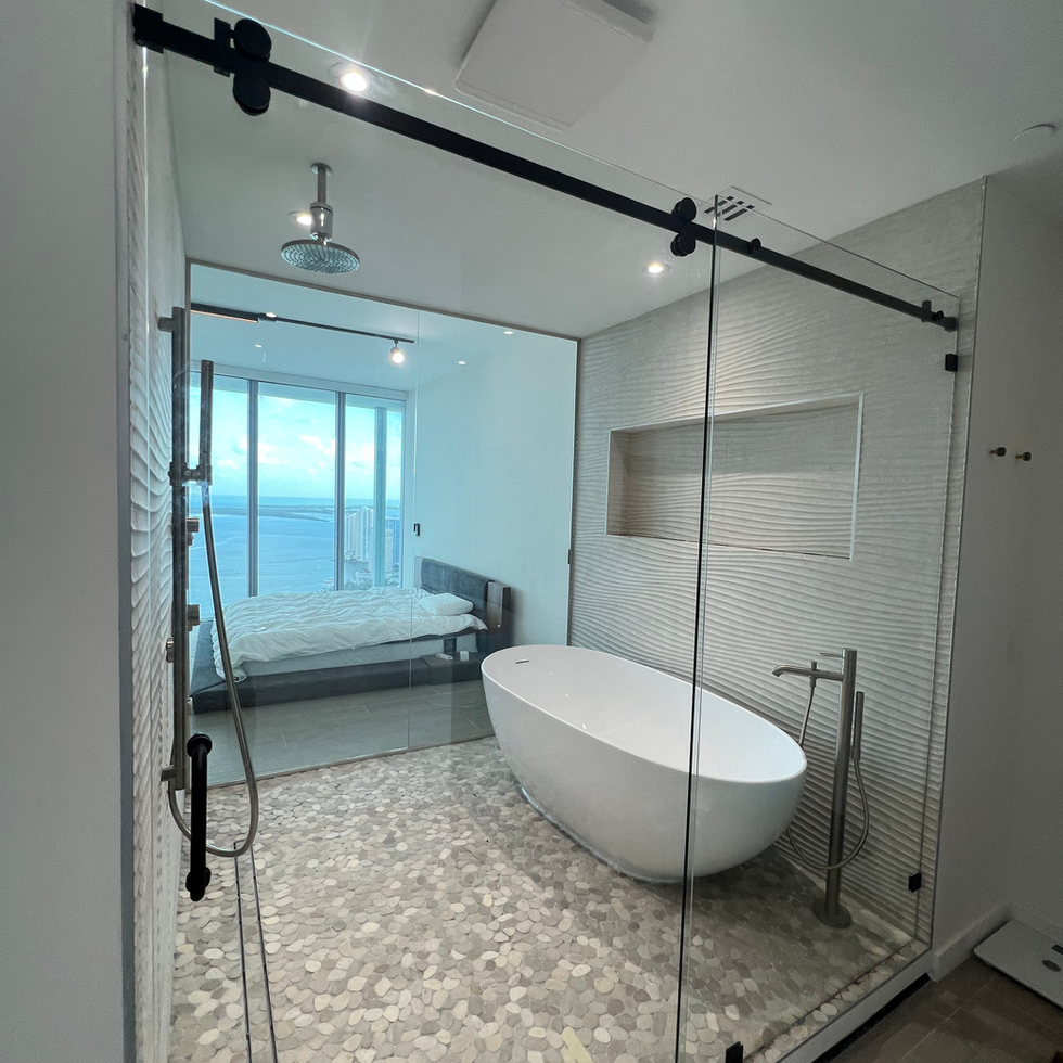 A bathroom with a bathtub and a sliding glass door