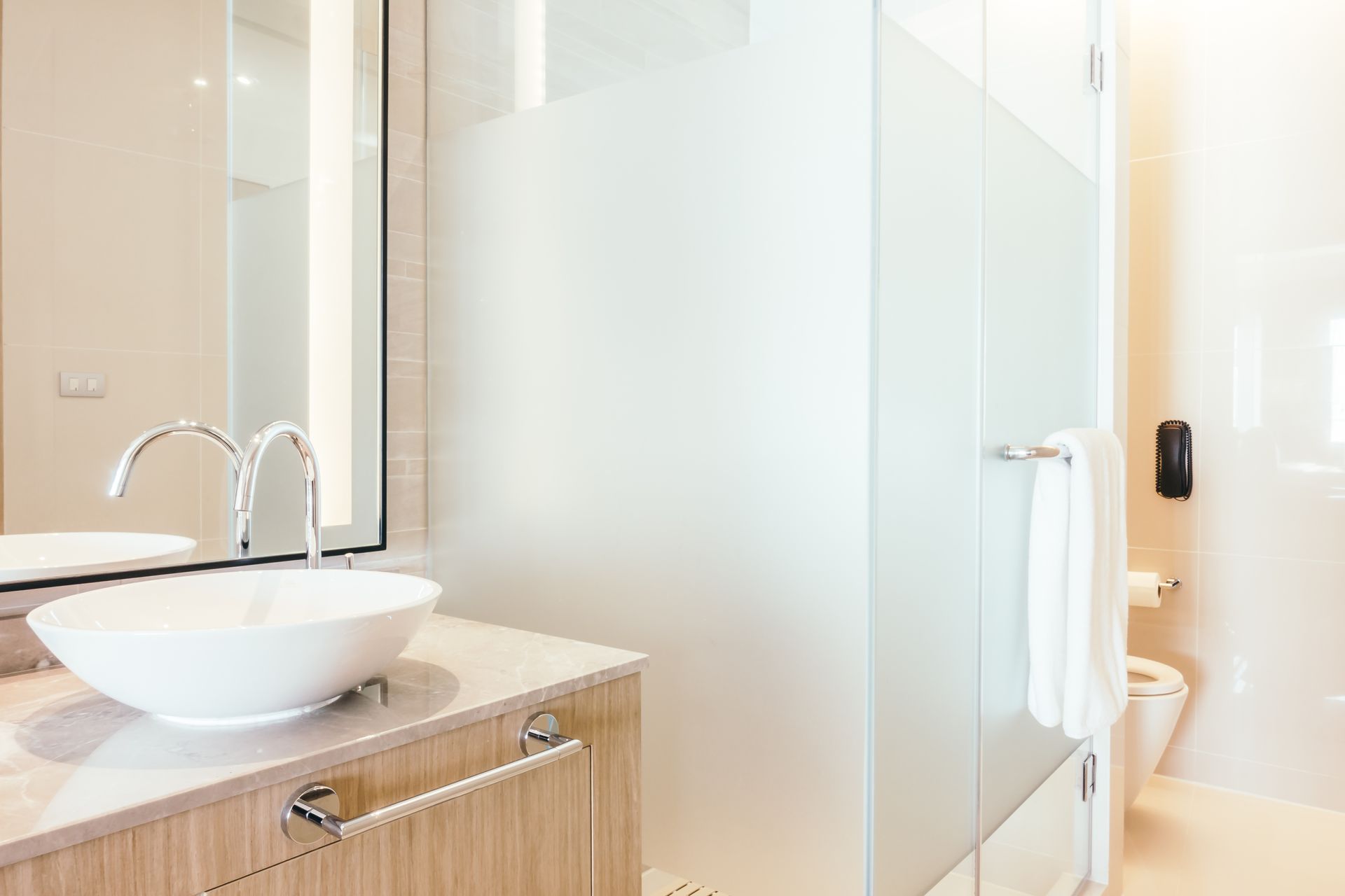 A bathroom with a sink , mirror , toilet and shower.