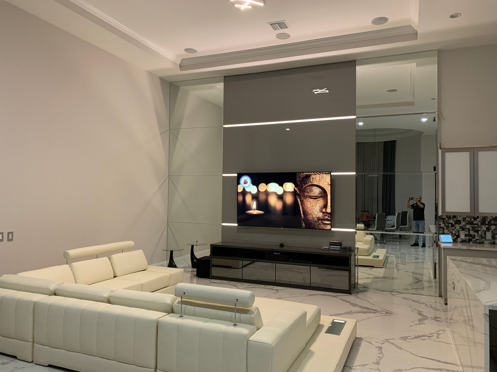 A living room with a couch and a television on the wall.