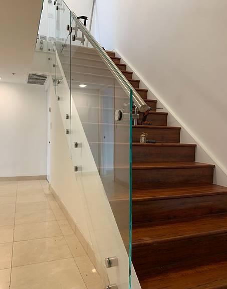 A staircase with a glass railing and wooden steps