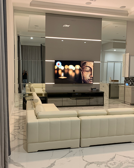 A living room with a couch and a television on the wall.