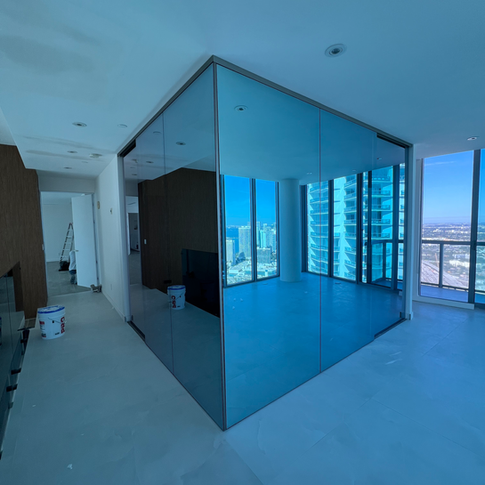 A room with a lot of windows and a blue glass wall