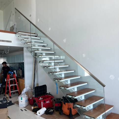 A staircase with a glass railing and wooden steps