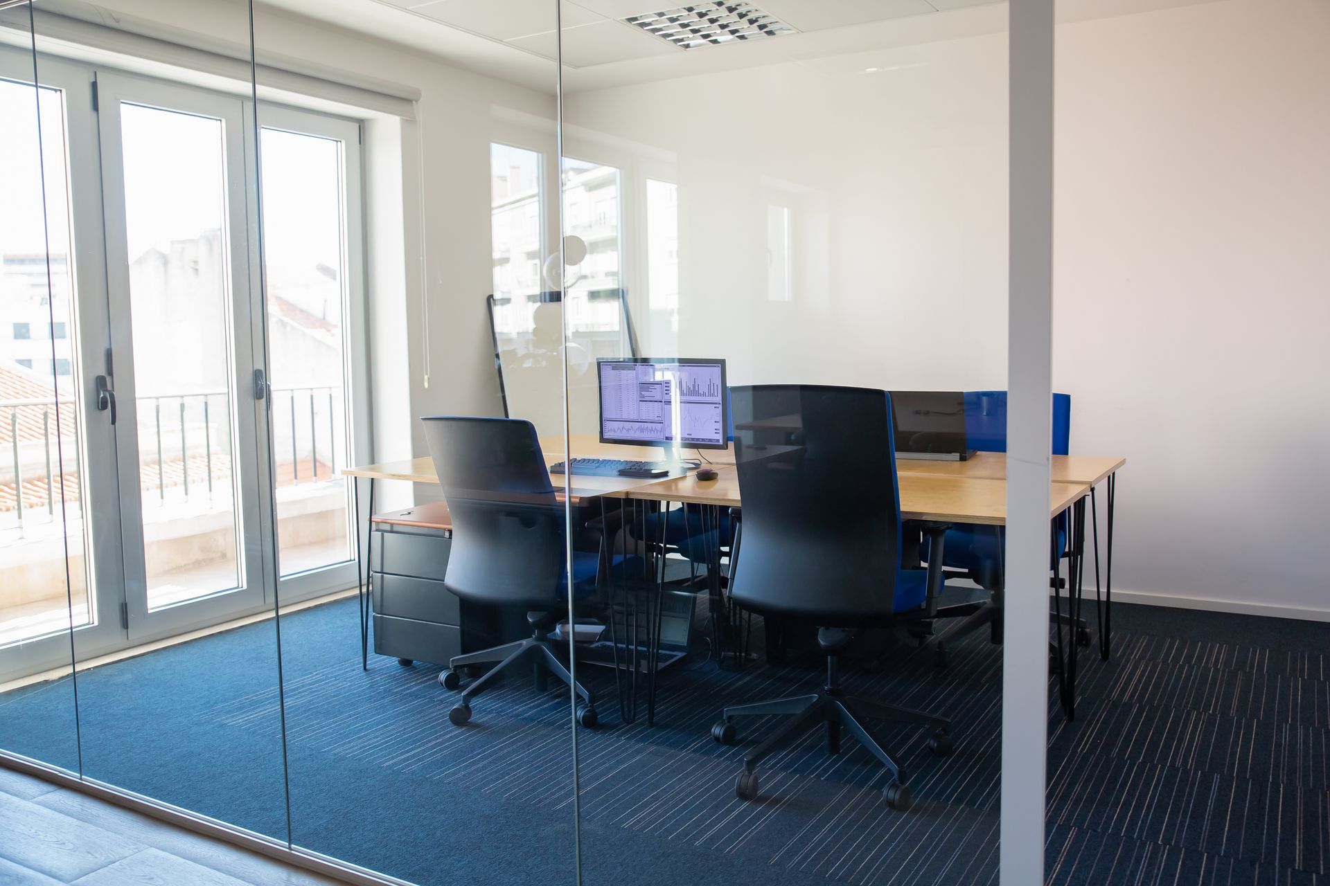 A conference room with tables and chairs and a glass wall