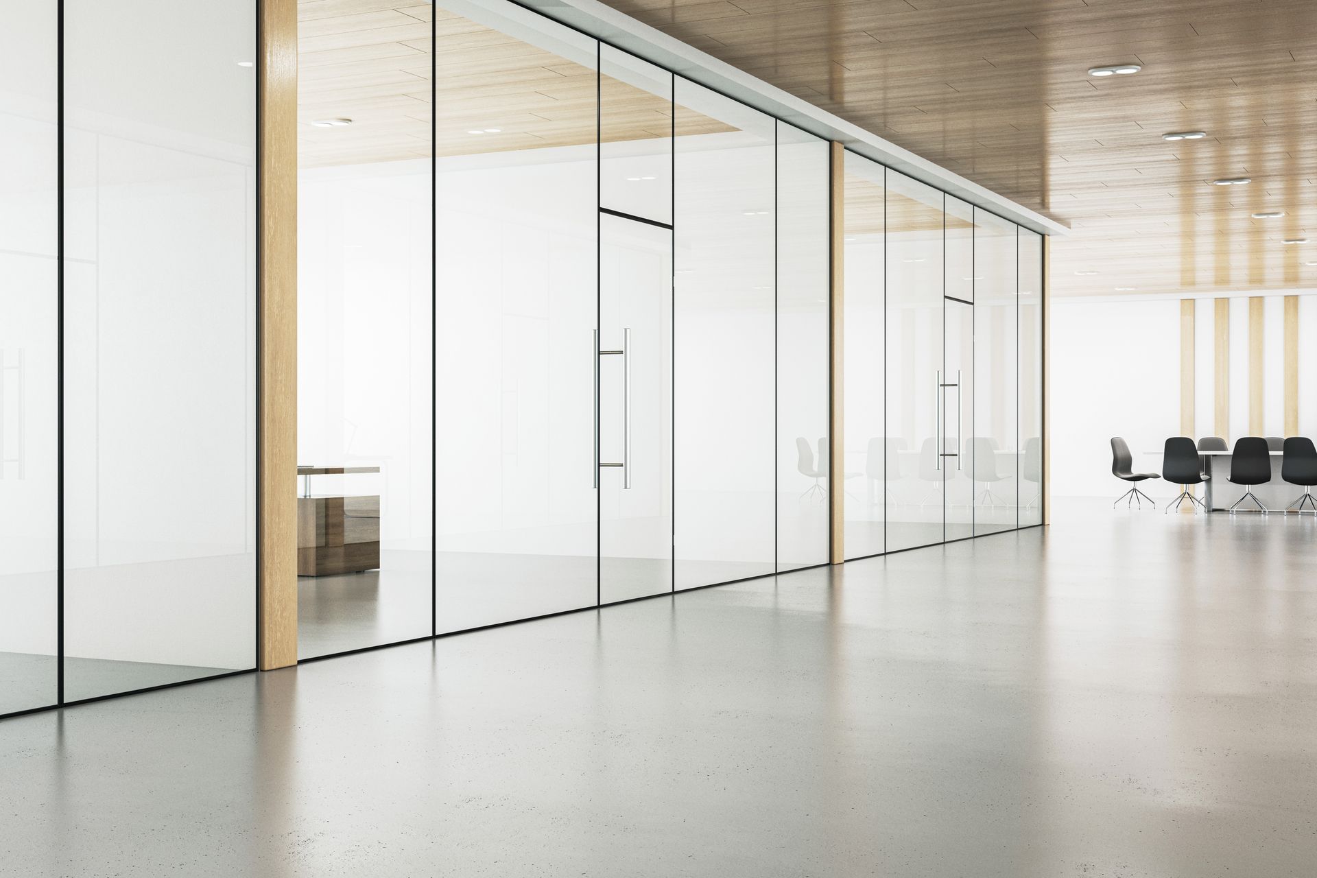 A long hallway with a lot of glass walls and chairs.