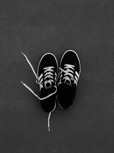 Un par de zapatillas blancas y negras con cordones blancos.