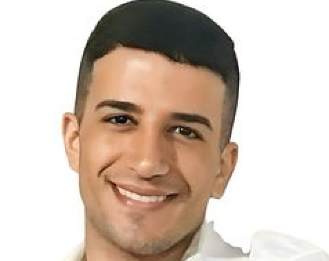 A young man in a white shirt is smiling for the camera.