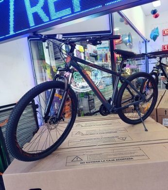 Una bicicleta está encima de una caja de cartón en una tienda.