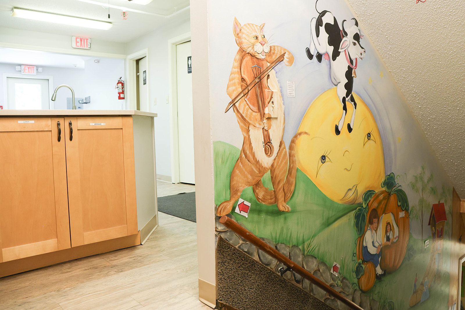 Hallway with mural of a cat playing a violin, cow, and other cartoon characters.