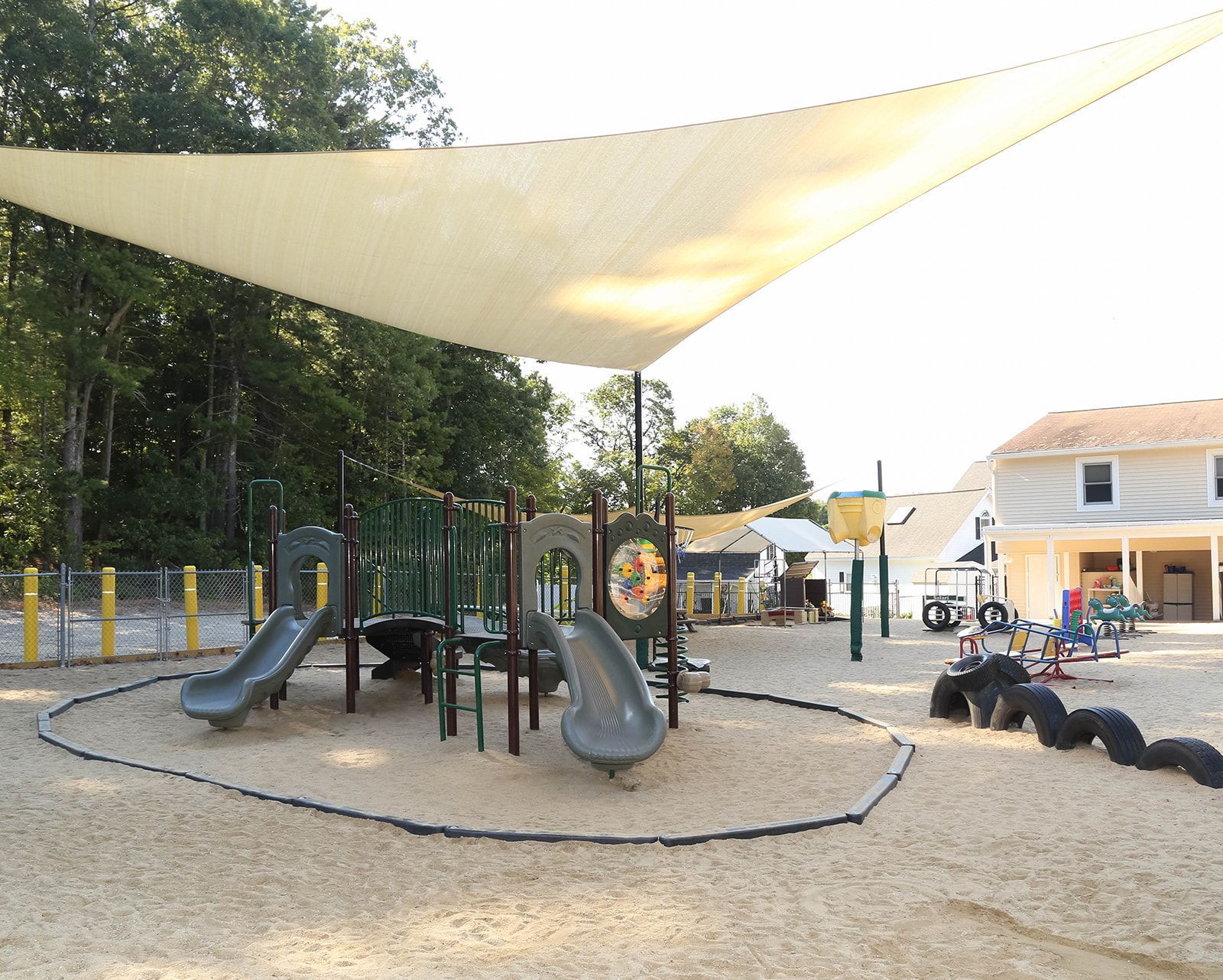 Playground with slides, climbing structures, and shade sail.