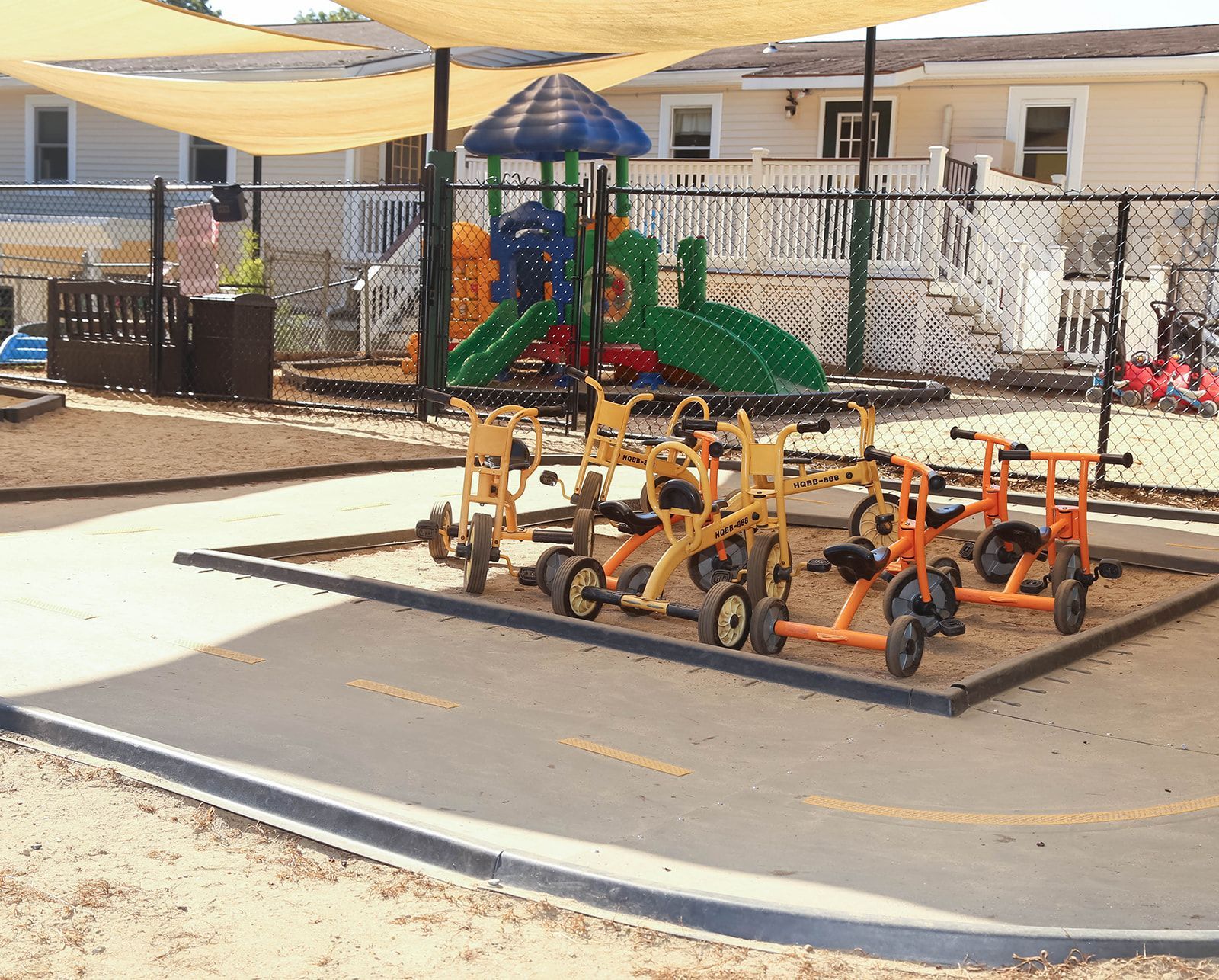 Playground with tricycles, slide, and shade cover.