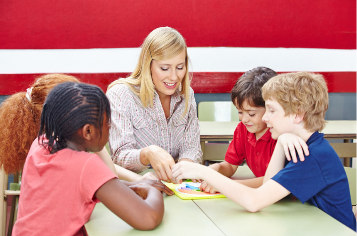 Teacher and four middle school students at a table