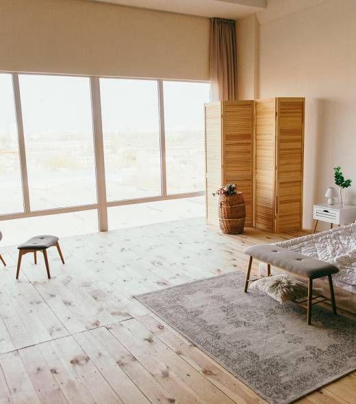 A living room with wooden floors, a couch, and a rug.