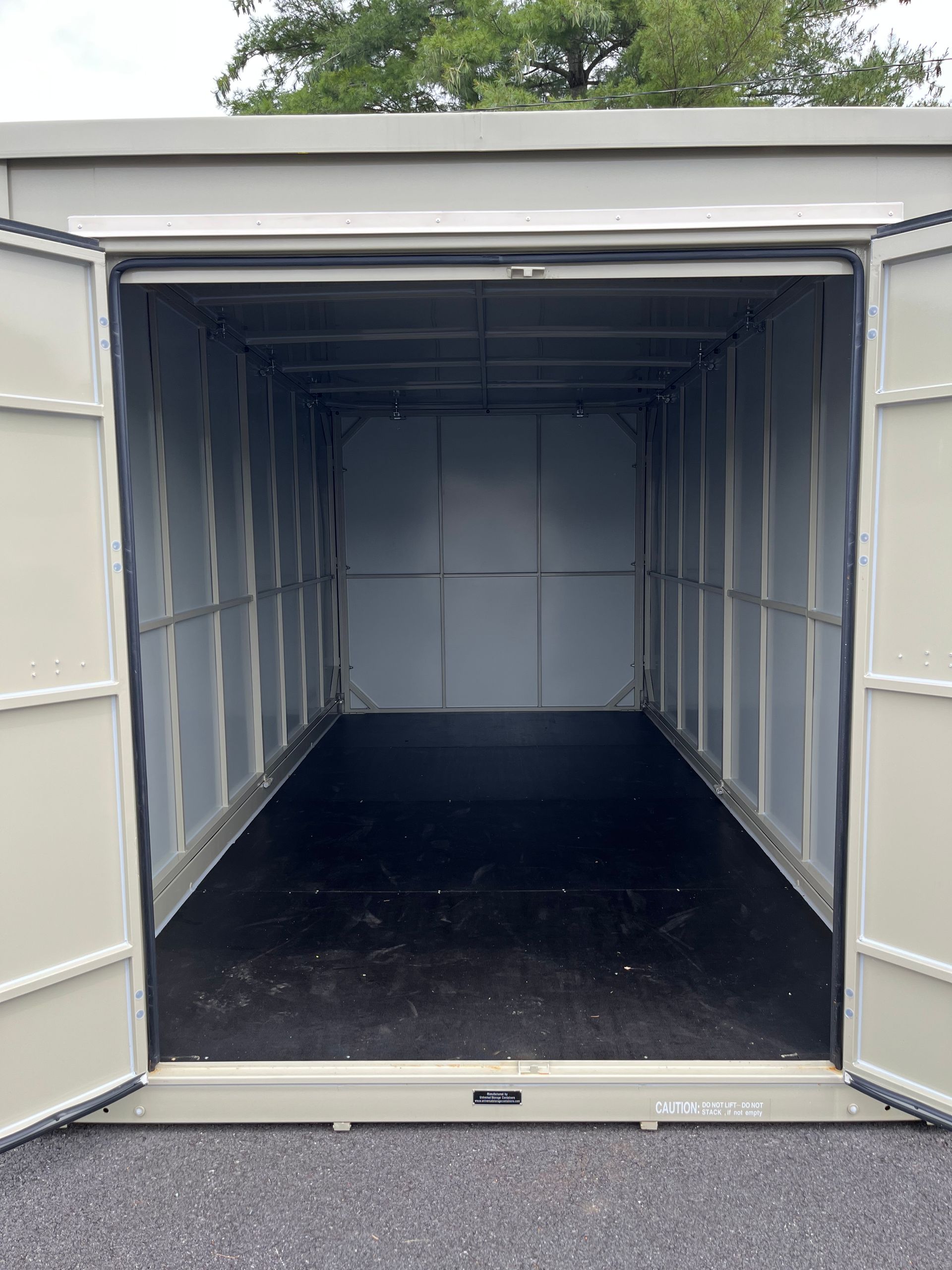 Open storage unit with gray walls and a black floor.