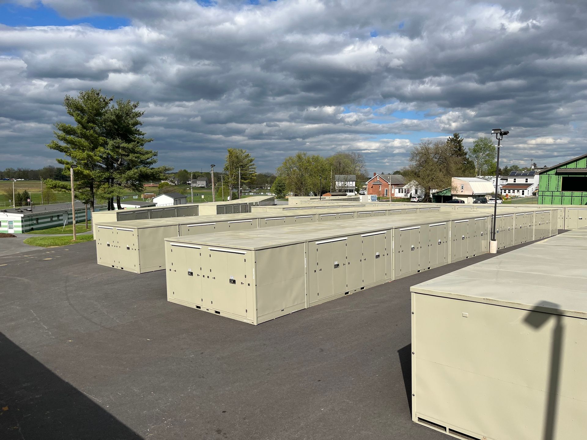 A row of self-storage containers are lined up in a parking lot at Garber Self storage.