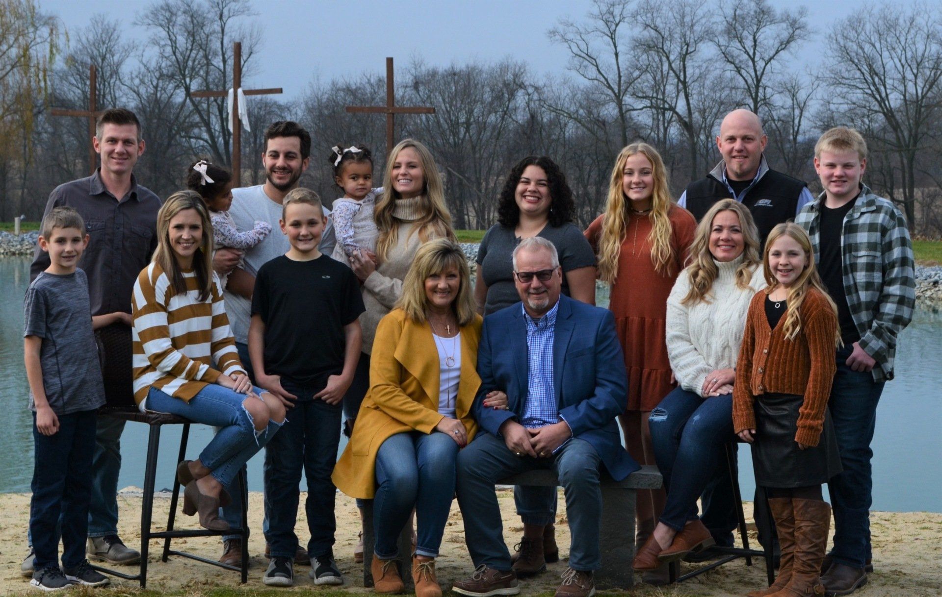 The Garber family from Garber self storage is posing for a picture in front of a lake.