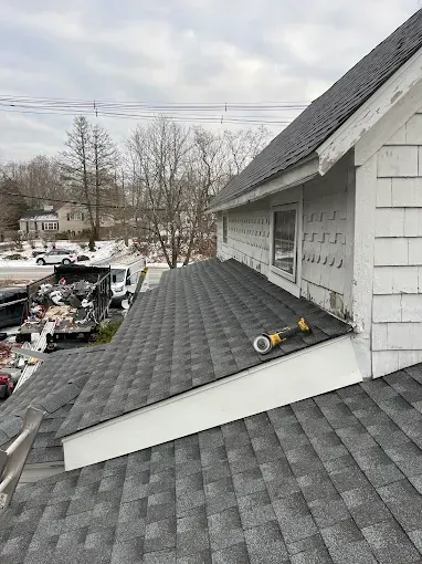 A house with a roof that is being built and a tool on the roof.