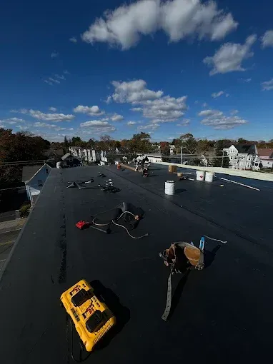 A black roof with a yellow tool on top of it.