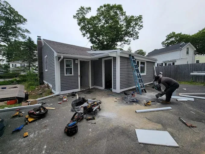 A man is working on the side of a house.