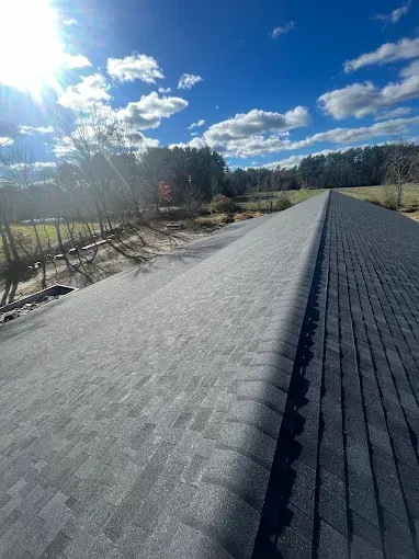 The sun is shining through the clouds on the roof of a house.