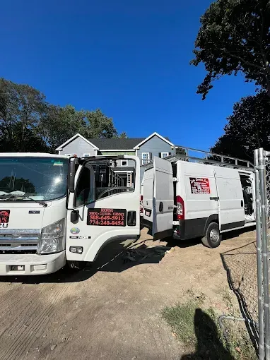Two trucks are parked in front of a house.
