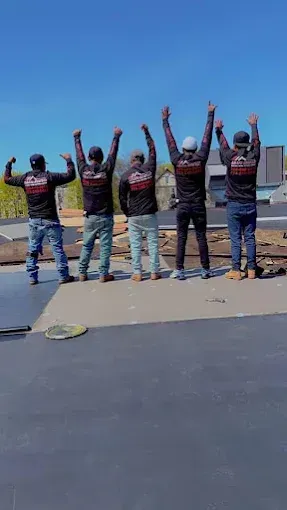 A group of men are standing next to each other with their arms in the air.