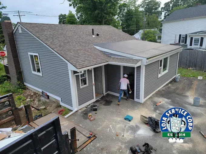 A man is standing in front of a house that is being remodeled.