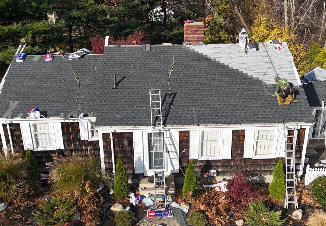 A roof with a lot of shingles on it and trees in the background.