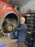 A man is working on a motorcycle in a garage.