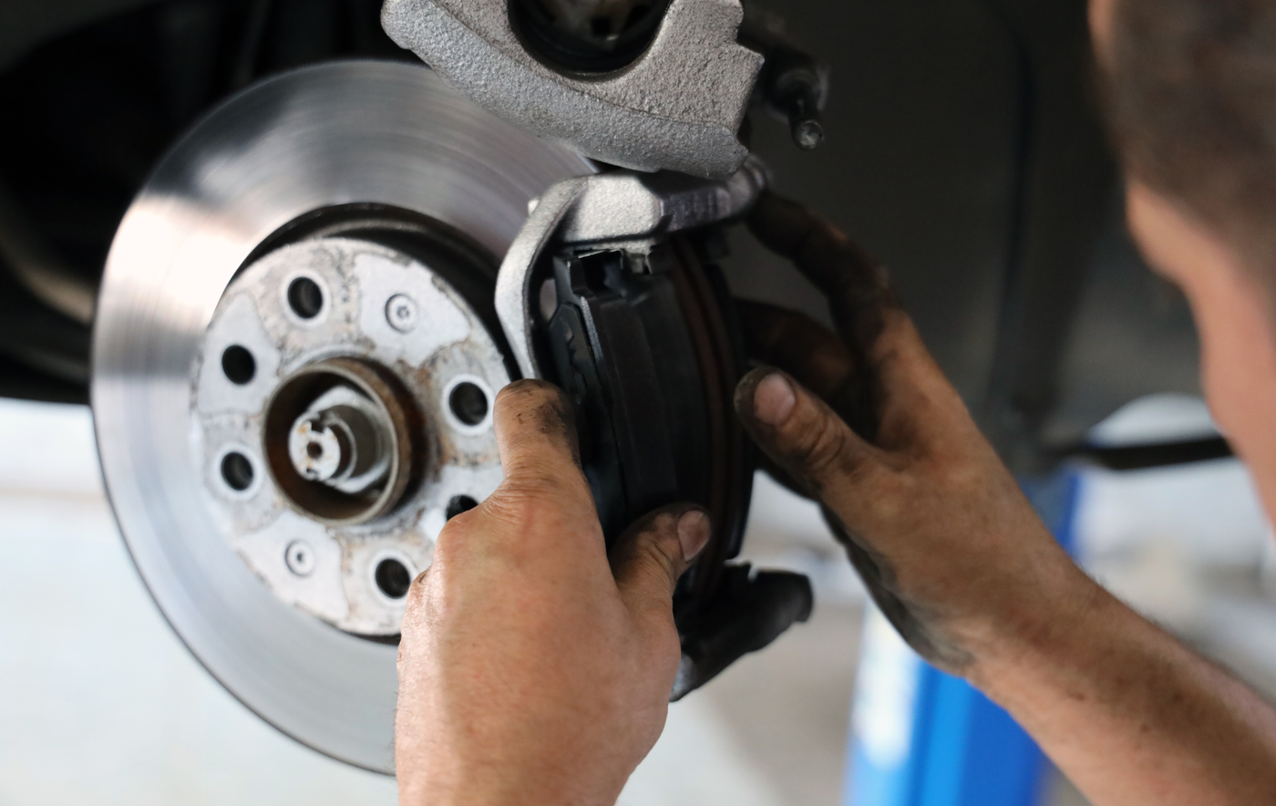 A person is fixing a brake disc on a car.