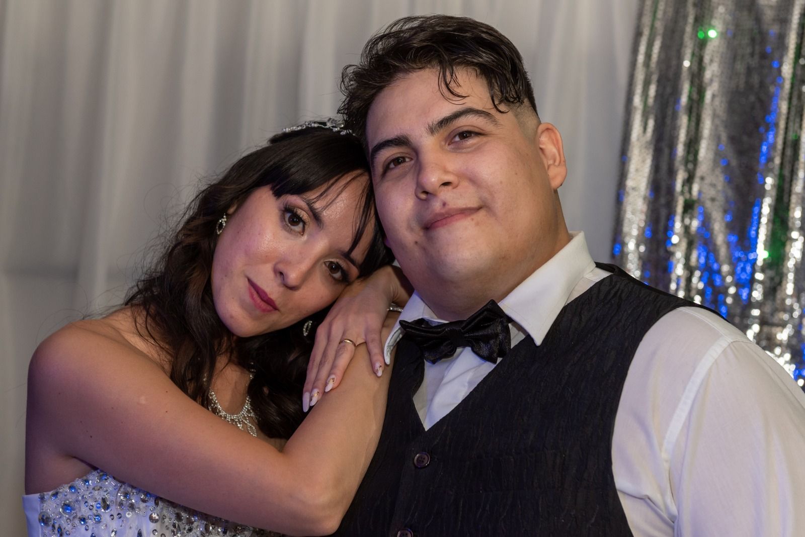 Una pareja se inclina, sonriendo. 