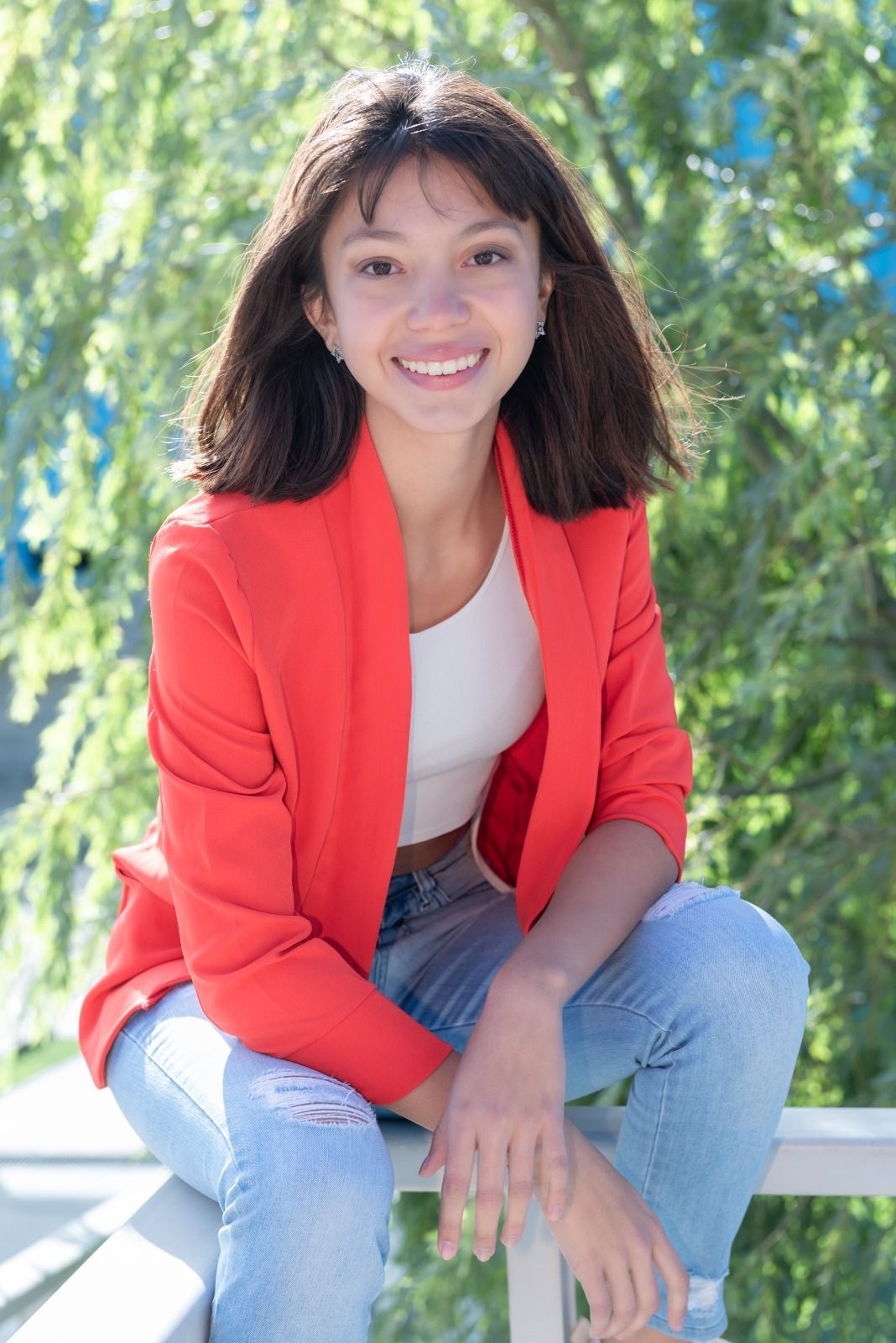 Mujer sonriendo, vestida con un blazer rojo