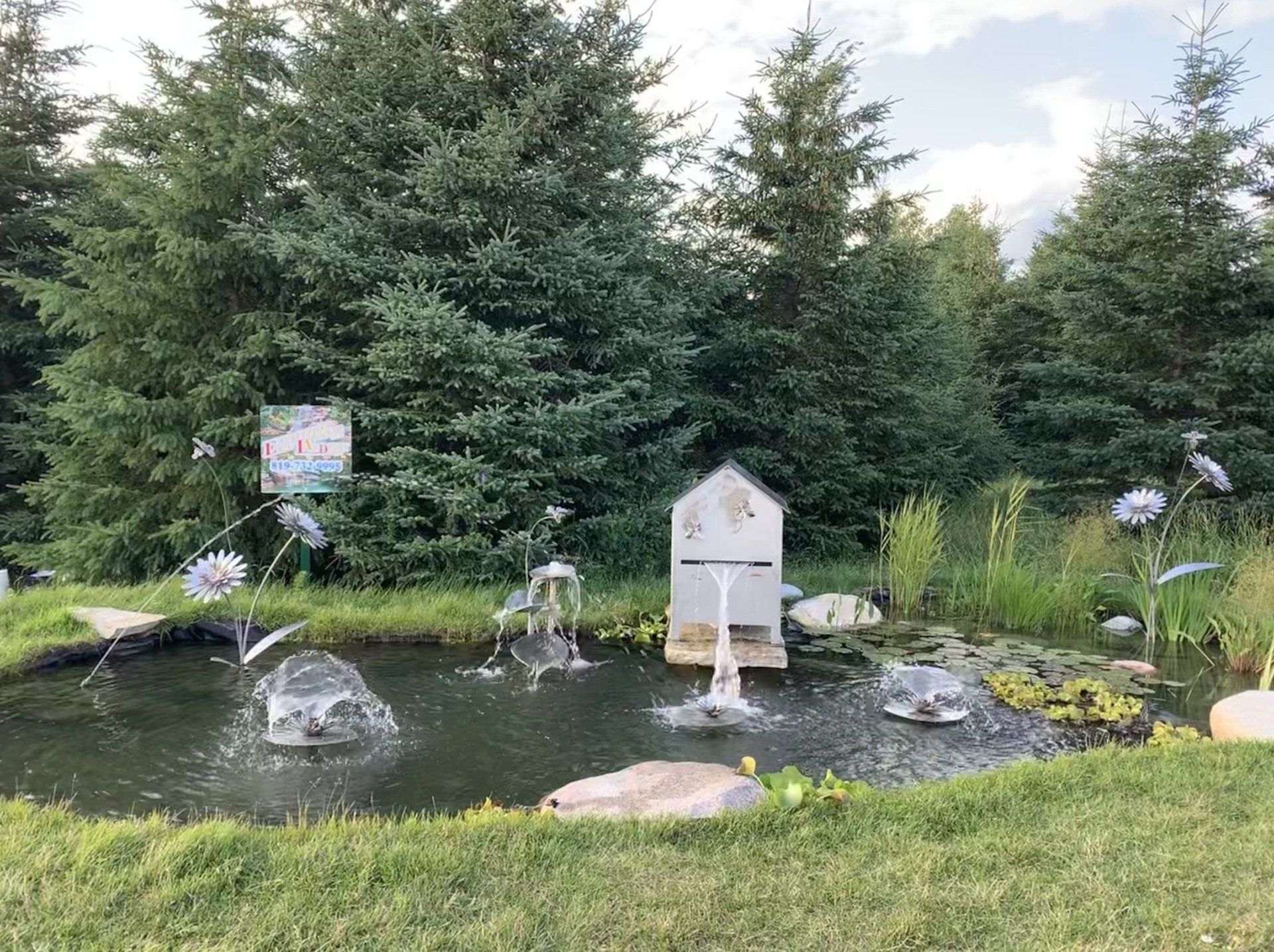 Il y a un étang avec une fontaine au milieu.