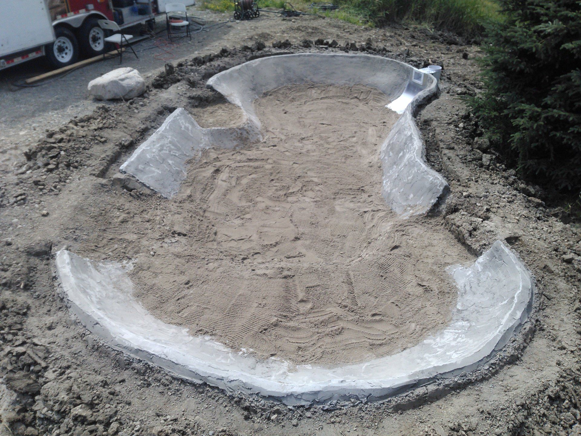 Une grande piscine est en cours de construction dans la terre.