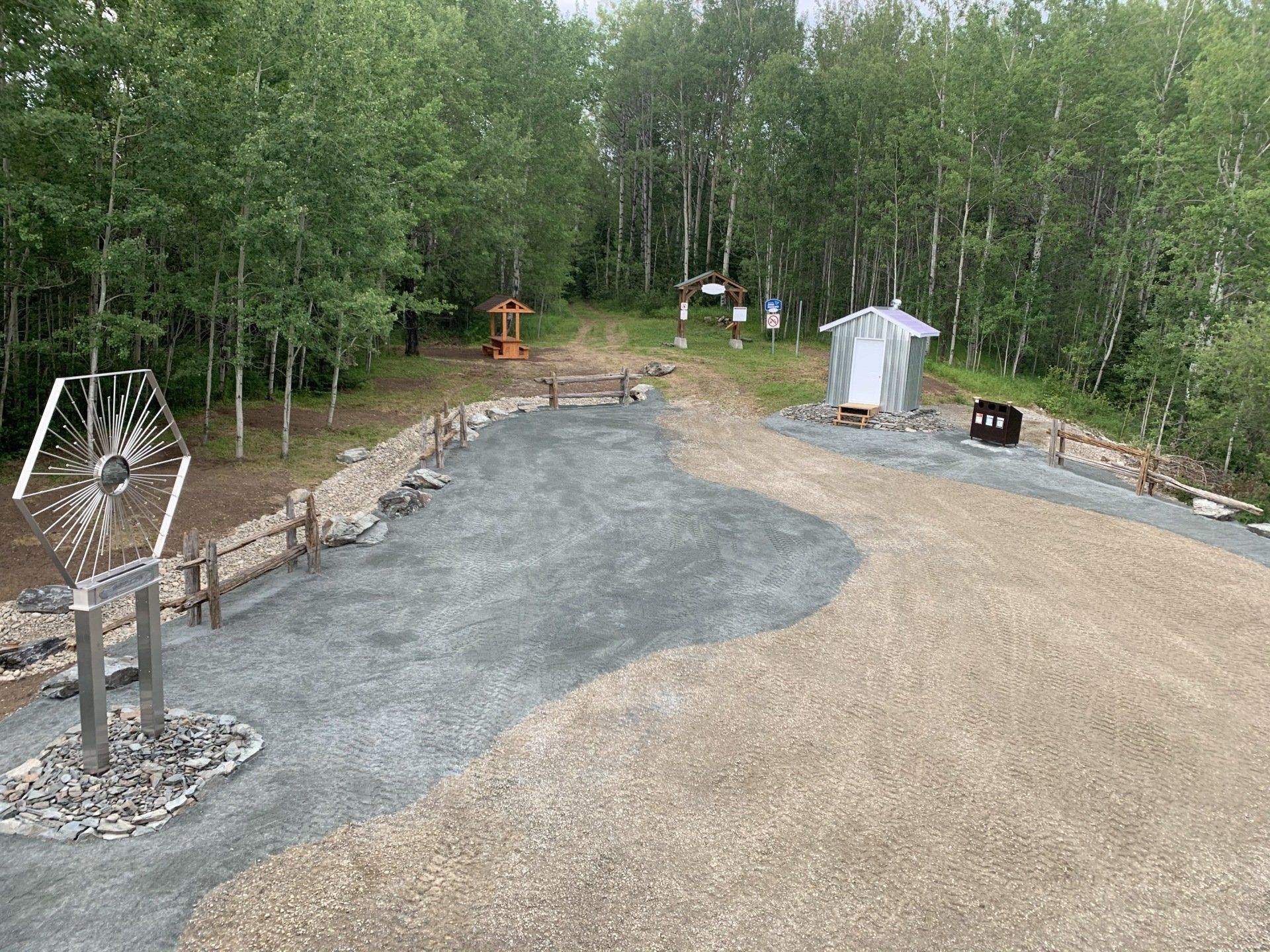 Un chemin de terre traversant une forêt avec des arbres des deux côtés.