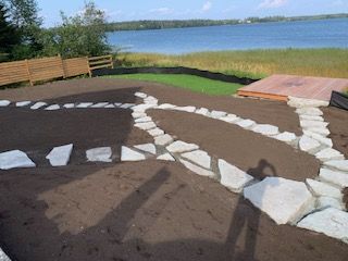Un grand bâtiment marron avec un mur de pierre devant.