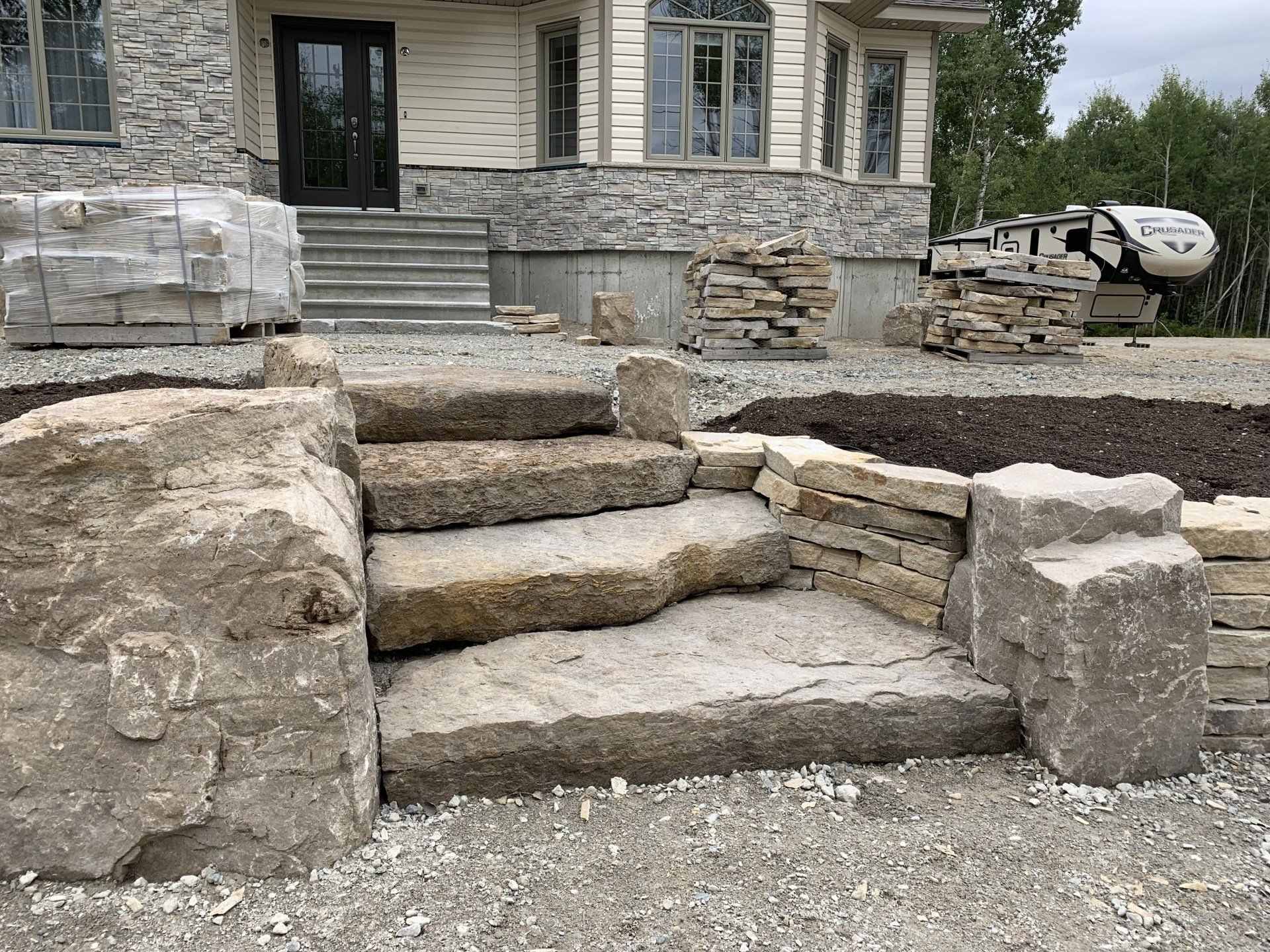 Un escalier en pierre est en cours de construction devant une maison.