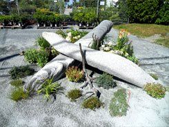 Une statue d avion est entourée de plantes dans un jardin.