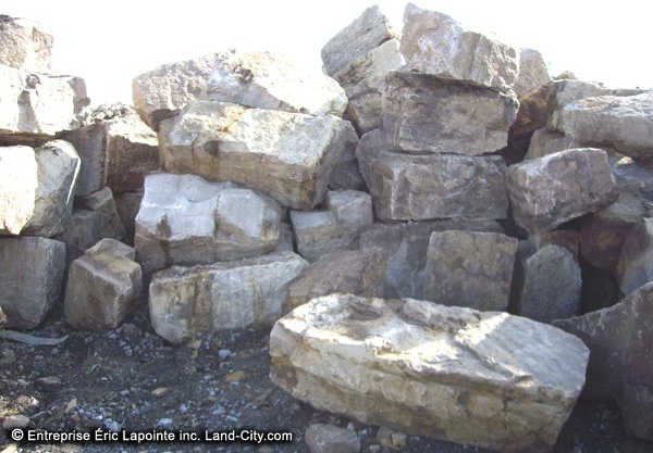 Un tas de roches avec l entreprise eric lacombe inc. écrit en bas