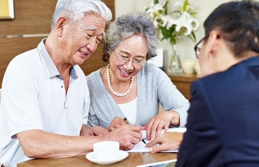 elderly asian couple meeting with lawyer