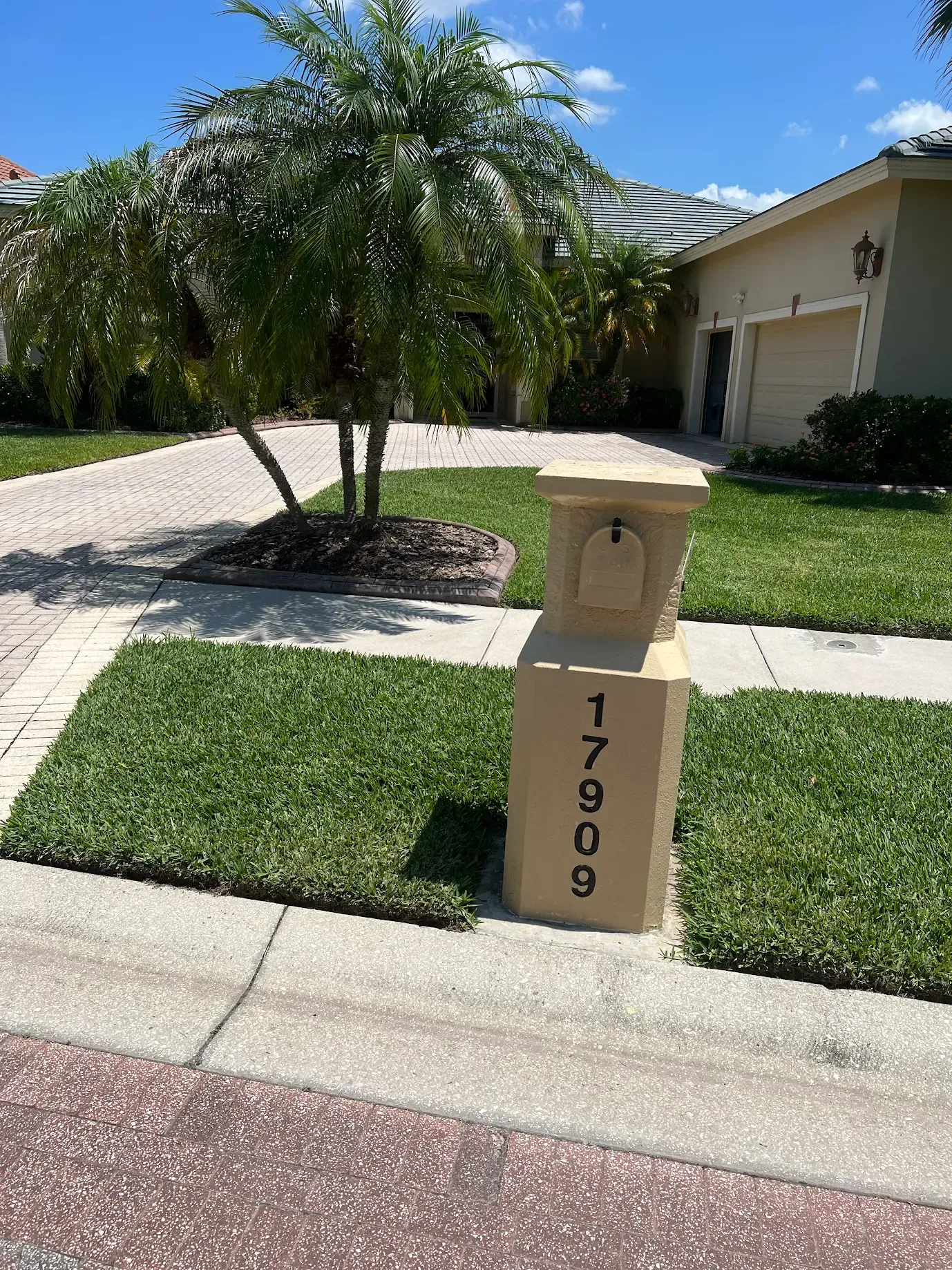 Josh Fertilizing Pro | A mailbox is sitting on the sidewalk in front of a house.