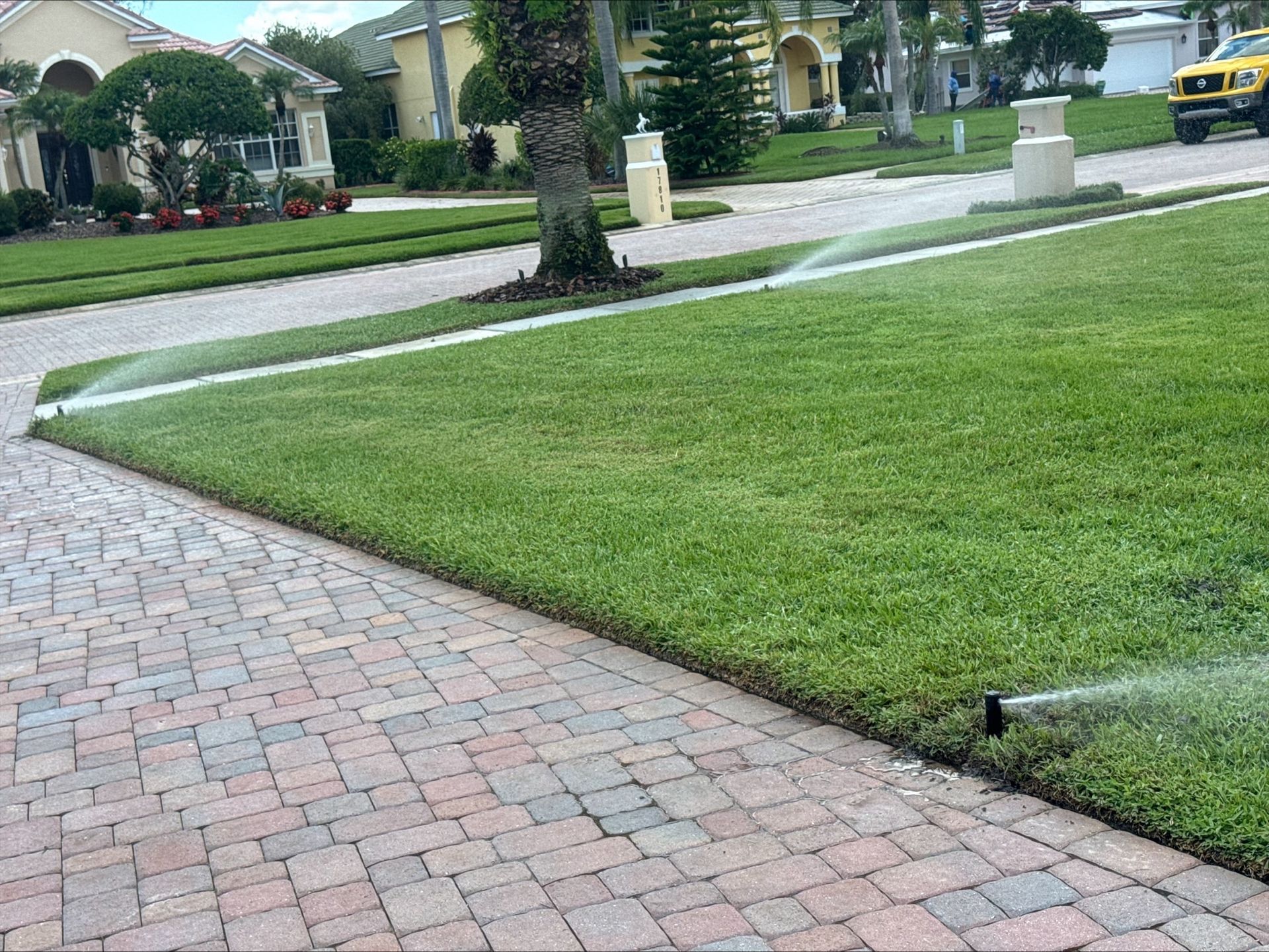 Josh Fertilizing Pro | A lawn sprinkler is spraying water on a lush green lawn.