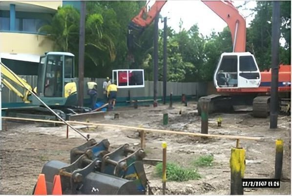 A Construction Site With a Large Orange Excavator in the Foreground — Q-Pile Foundations in Coolum Beach, QLD