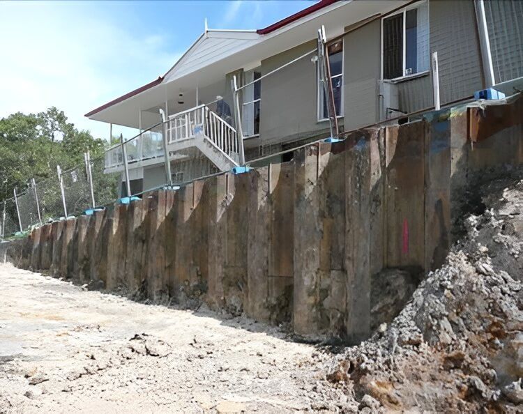 A House is Being Built on a Hill Next to a Large Wall — Q-Pile Foundations in Coolum Beach, QLD