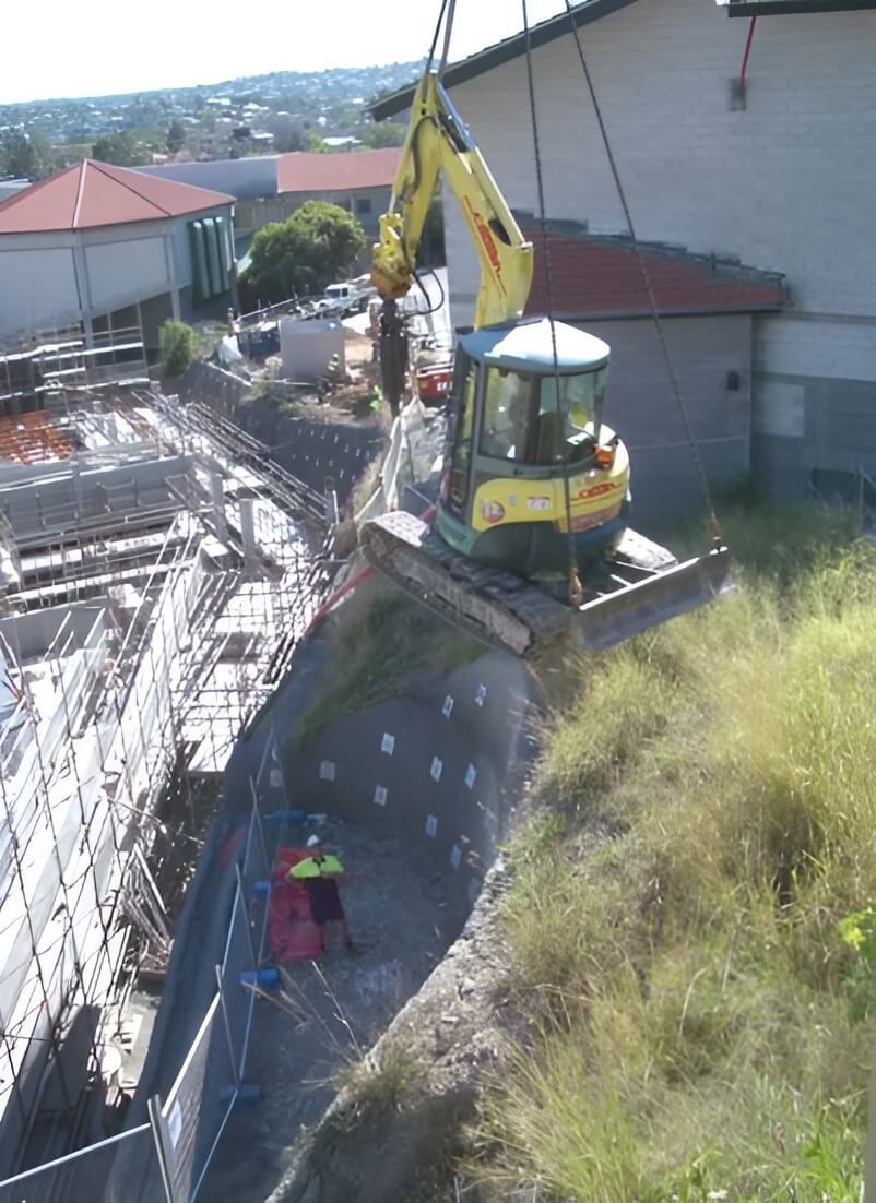 A Yellow Excavator is Being Lifted by a Crane — Q-Pile Foundations in Gympie, QLD